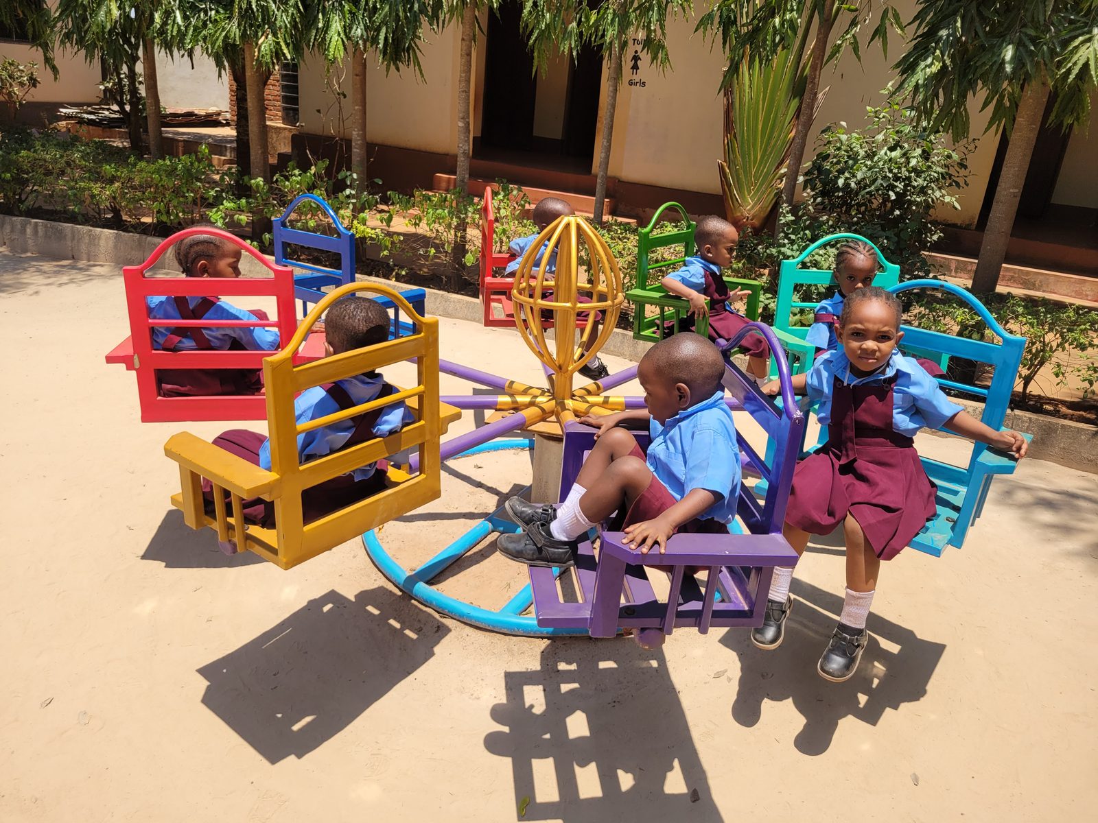 Day care children in uniform riding the merry-go-round